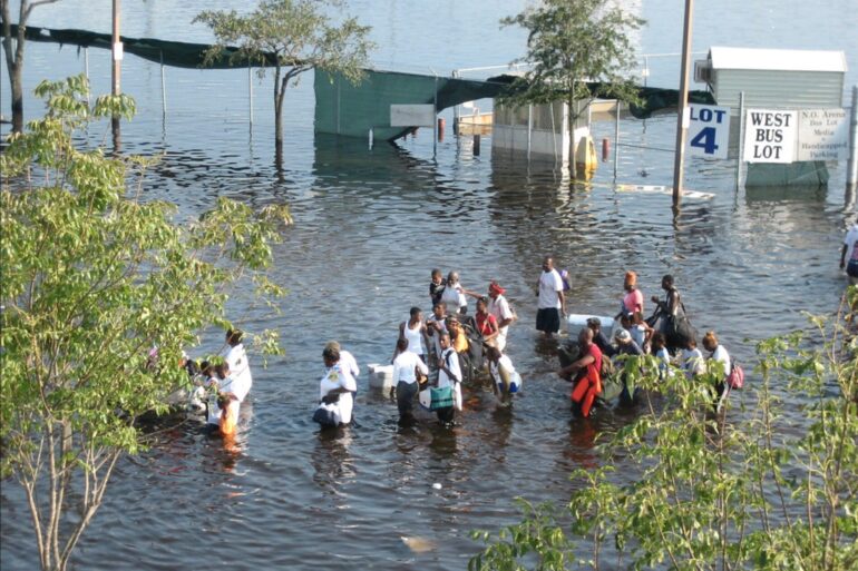 A group of hurricane katrina survivors wade through flood waters